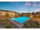 Stunning backyard pool with Baja shelf, a covered outdoor dining area, and lush landscaping create a perfect backyard retreat at 20426 E Arroyo Verde Dr, Queen Creek, AZ 85142