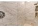 Luxurious shower with white marble-style tiles, and a built-in niche for storage at 20426 E Arroyo Verde Dr, Queen Creek, AZ 85142