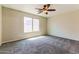 Bright bedroom featuring large window, ceiling fan and carpeted floor at 2129 E Yuma Ave, Apache Junction, AZ 85119