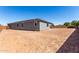 Flat, large backyard with low brick wall around the perimeter and clear blue sky at 21348 N Belt Dr, Maricopa, AZ 85138