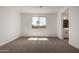 Bright bedroom with neutral carpet, white walls, and a window providing natural light at 21348 N Belt Dr, Maricopa, AZ 85138