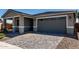 Charming gray single-Gathering home with a brick driveway and attached two-car garage at 21348 N Belt Dr, Maricopa, AZ 85138