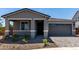 Single-Gathering home with gray siding, a two-car attached garage and desert landscaping at 21348 N Belt Dr, Maricopa, AZ 85138
