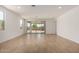 Bright living room with neutral tile flooring, white walls, sliding glass door, and lots of natural light at 21348 N Belt Dr, Maricopa, AZ 85138
