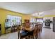Open dining room with tile floors, bright yellow walls, and traditional wood furniture at 2202 W Enid Ave, Mesa, AZ 85202
