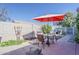 Backyard patio area with outdoor dining set and red umbrella at 2202 W Enid Ave, Mesa, AZ 85202