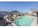 Inviting backyard pool with a rock waterfall feature, surrounded by a privacy fence and lush landscaping at 2202 W Enid Ave, Mesa, AZ 85202