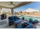 Relaxing covered patio showcases outdoor seating and a refreshing view of the private swimming pool and backyard at 24638 N 144Th Ave, Surprise, AZ 85387