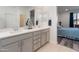 Well-lit bathroom with double vanity, a white countertop, and a view into the main bedroom at 24638 N 144Th Ave, Surprise, AZ 85387