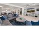 Open-concept living room boasts a sleek sectional, modern decor, and seamless flow into the kitchen at 24638 N 144Th Ave, Surprise, AZ 85387