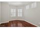 Sunlit bedroom with hardwood floors and two large shuttered windows at 2957 E Melrose St, Gilbert, AZ 85297