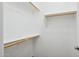 Walk-in closet with wooden clothing rods and white shelving at 2957 E Melrose St, Gilbert, AZ 85297