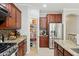 Well-organized kitchen featuring stainless steel refrigerator, granite countertops and dark wood cabinetry at 2957 E Melrose St, Gilbert, AZ 85297