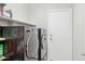 Modern laundry room features front loading washer and dryer, utility sink, and ample shelving space at 2957 E Melrose St, Gilbert, AZ 85297