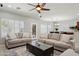 Open-concept living area featuring neutral furniture, ceiling fan and seamless flow into dining area at 2957 E Melrose St, Gilbert, AZ 85297