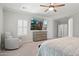 Neutral-toned bedroom featuring a ceiling fan, shuttered windows, and plush seating at 2957 E Melrose St, Gilbert, AZ 85297
