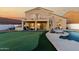 Stunning backyard oasis with pool, sun loungers, putting green, and covered patio at 33828 N Pate Pl, Cave Creek, AZ 85331