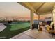 Relaxing covered patio with outdoor seating overlooks manicured putting green at 33828 N Pate Pl, Cave Creek, AZ 85331