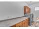 Laundry room with ample counter space, wood cabinets, and modern appliances. Wood-look flooring at 3806 E Taurus Pl, Chandler, AZ 85249