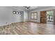 Bright living room featuring wood-look tile floors, natural light, and access to the backyard at 3806 E Taurus Pl, Chandler, AZ 85249