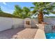 Outdoor fireplace with seating and pavers, complemented by lush landscaping and blue skies at 3806 E Taurus Pl, Chandler, AZ 85249