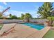 Backyard swimming pool with stone trim, artificial turf, surrounding landscaping, and outdoor fireplace at 3806 E Taurus Pl, Chandler, AZ 85249