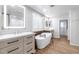 Bright bathroom features a soaking tub, dual vanities, wood accents, and a door to the walk-in closet at 3813 W Lapenna Dr, New River, AZ 85087