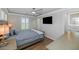 A bedroom with a ceiling fan, and a TV features wood look floors and a view to the bathroom at 3813 W Lapenna Dr, New River, AZ 85087
