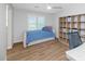 Bright bedroom features wood flooring, a modern ceiling fan, and a stylish daybed with a vibrant blue cover at 3813 W Lapenna Dr, New River, AZ 85087
