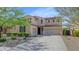 Inviting two-story home featuring a three-car garage, desert landscaping, and a classic tile roof at 3813 W Lapenna Dr, New River, AZ 85087