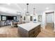 Open-concept kitchen featuring a large island, stainless appliances, and an adjacent dining and living area at 3813 W Lapenna Dr, New River, AZ 85087