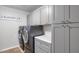 Functional laundry room showcasing gray cabinets, countertops, and modern washer and dryer sets at 3813 W Lapenna Dr, New River, AZ 85087