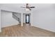 Bright living room with stylish laminate flooring, a ceiling fan, and staircase access at 3813 W Lapenna Dr, New River, AZ 85087