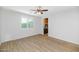 Neutral-toned room with laminate flooring, a ceiling fan, a large window, and a peek at a wet bar at 3813 W Lapenna Dr, New River, AZ 85087