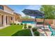 Inviting pool area with a covered patio, comfortable seating, and well-manicured landscaping at 3813 W Lapenna Dr, New River, AZ 85087