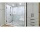 A glass-enclosed marble shower features dual shower heads and a bench with coordinating built-in storage at 3813 W Lapenna Dr, New River, AZ 85087