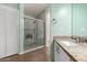 Bathroom with marble-tiled shower featuring glass doors and gray vanity at 385 E Ironwood Dr, Chandler, AZ 85225