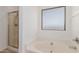 This is a bathroom with a shower, a soaking tub, tile flooring and a frosted window at 3929 W Goldmine Mountain Dr, San Tan Valley, AZ 85144