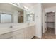Bright bathroom with double vanity sinks, a walk-in shower, and a separate linen closet at 3929 W Goldmine Mountain Dr, San Tan Valley, AZ 85144