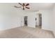 Large bedroom features neutral carpet, ceiling fan, and views into the on-suite bathroom at 3929 W Goldmine Mountain Dr, San Tan Valley, AZ 85144