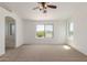 Large bedroom featuring neutral carpet, a ceiling fan and large windows offering great natural light and mountain views at 3929 W Goldmine Mountain Dr, San Tan Valley, AZ 85144