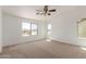 Spacious bedroom with neutral carpet, a ceiling fan and large windows offering great natural light at 3929 W Goldmine Mountain Dr, San Tan Valley, AZ 85144