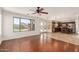 Spacious living room featuring hardwood floors and large windows overlooking the backyard and opening into the kitchen at 3929 W Goldmine Mountain Dr, San Tan Valley, AZ 85144
