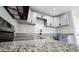 Modern kitchen featuring granite counters, stainless appliances, and shaker cabinets at 4219 W Citrus Way, Phoenix, AZ 85019