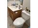Cozy bathroom featuring a white toilet and a vanity with a white countertop and wooden cabinets at 4322 E Cottonwood Ln, Phoenix, AZ 85048
