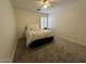 Neutral bedroom with a ceiling fan, carpet, and light-filled window at 4322 E Cottonwood Ln, Phoenix, AZ 85048