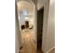 Hallway view of the pantry with shelving and the living area with hardwood floors at 4322 E Cottonwood Ln, Phoenix, AZ 85048