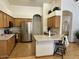 Bright kitchen featuring stainless steel refrigerator, oak cabinets, and island at 4322 E Cottonwood Ln, Phoenix, AZ 85048
