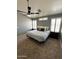 Cozy main bedroom features neutral colors, a ceiling fan, and natural light from shuttered windows at 4322 E Cottonwood Ln, Phoenix, AZ 85048
