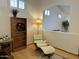 A cozy sitting area with wood floors, a modern chair, and natural light streaming through the windows at 4322 E Cottonwood Ln, Phoenix, AZ 85048